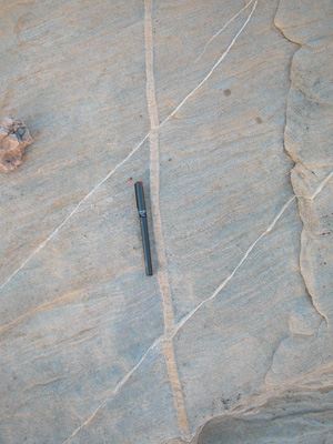 Two shear bands (diagonal) offsetting a compaction band (N-S or up and down) in Aztec Sandstone, Valley of Fire State Park (NV). Notice that the shear bands are much thinner than the compaction band.